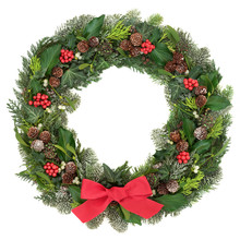 Christmas Wreath Decoration With A Red Bow, Holly, Mistletoe, Snow Covered Juniper Fir, Blue Spruce, Cedar, Pine Cones  And Ivy Leaves On White Background.