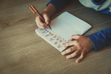 Wall Mural - little boy learning to write letters doing homework