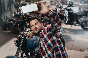 Wall Mural - man taking selfie with motorcycle