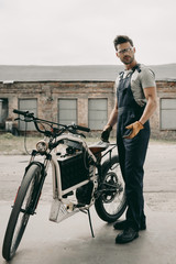 Wall Mural - mechanic in goggles repairing motorcycle