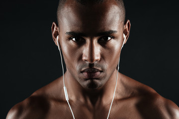 Close-up photo of serious afro american young man, looking at camera