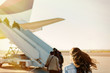© vladteodor - Young woman passager walking from the airport terminal to the airplane for departure.