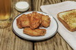 hot wings with toast and a cold beer on a wooden background
