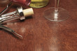 cork screw with wine bottles and a wine glass on a wooden table