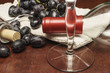 wine glass with a bottle and cork screw surrounded     by grapes