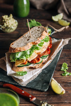 Delicious Sandwich With Salad, Tofu, Avocado, Cucumbers And Dried Tomatoes On Wooden Table