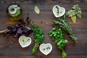 Poster - natural oil and fresh greenery for restaurant cooking on wooden kitchen table background top view