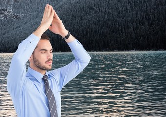 Poster - Business man meditating against water and trees on hill