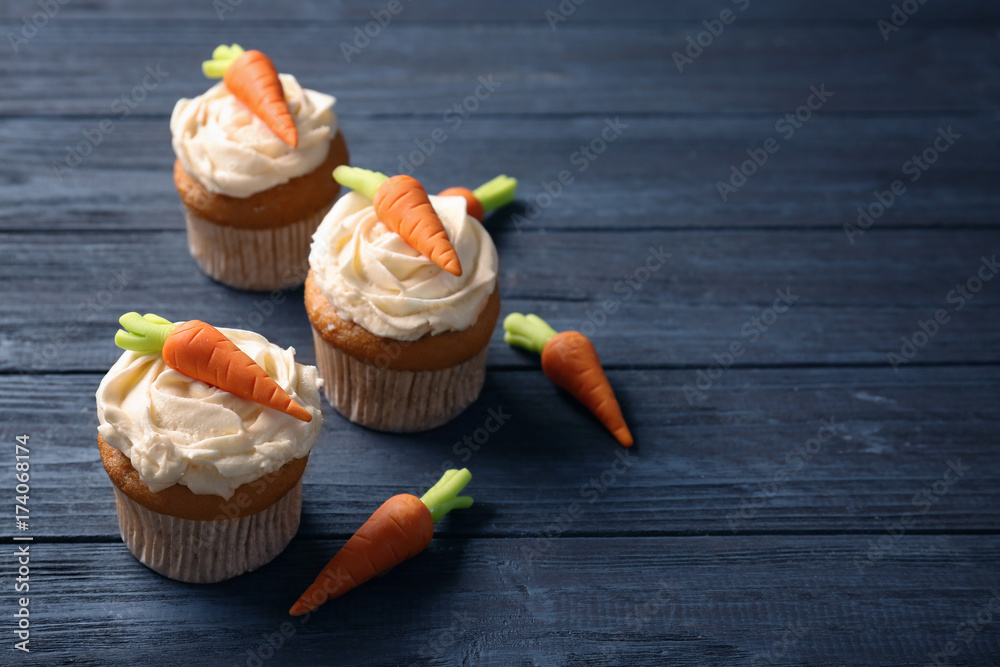 Delicious carrot cupcakes on wooden background