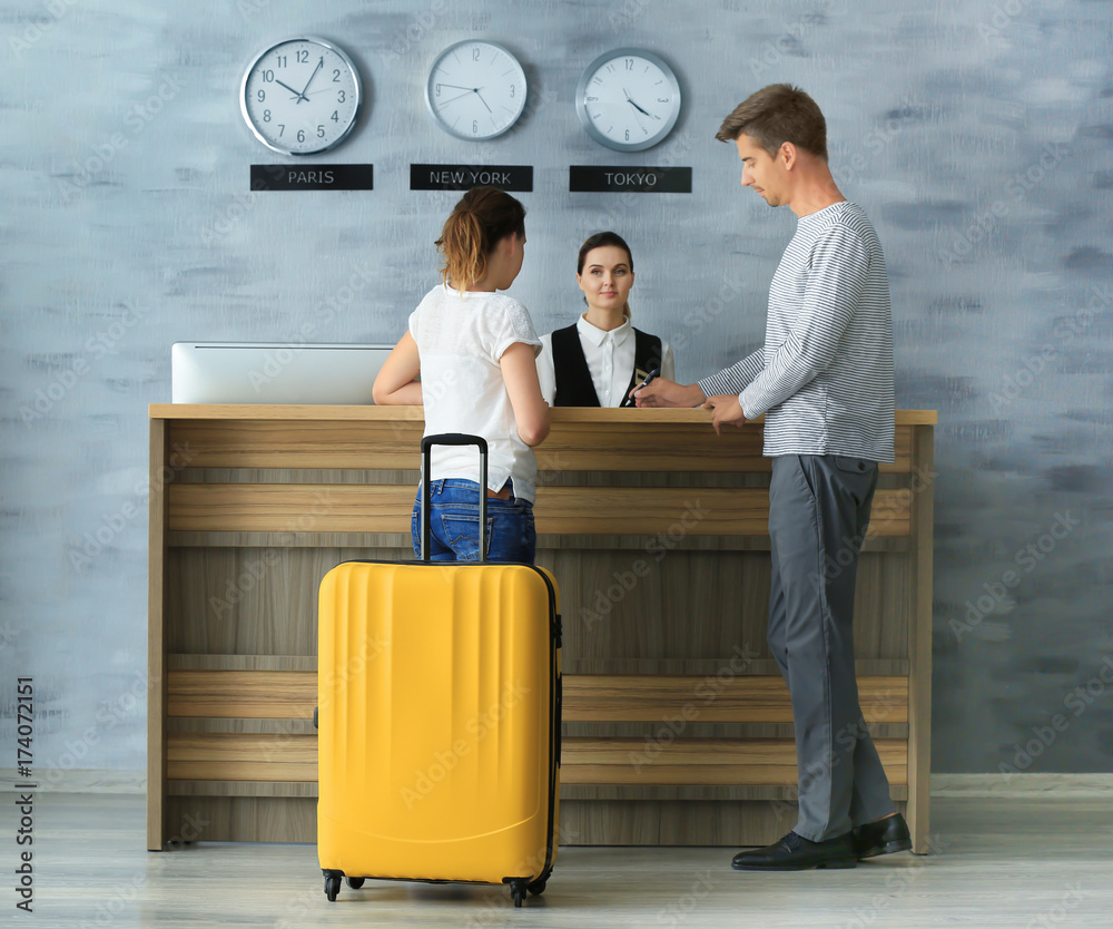 Young couple at reception desk in hotel