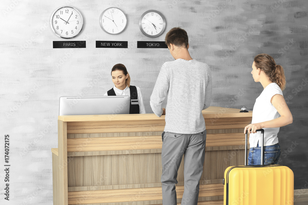 Young couple at reception desk in hotel