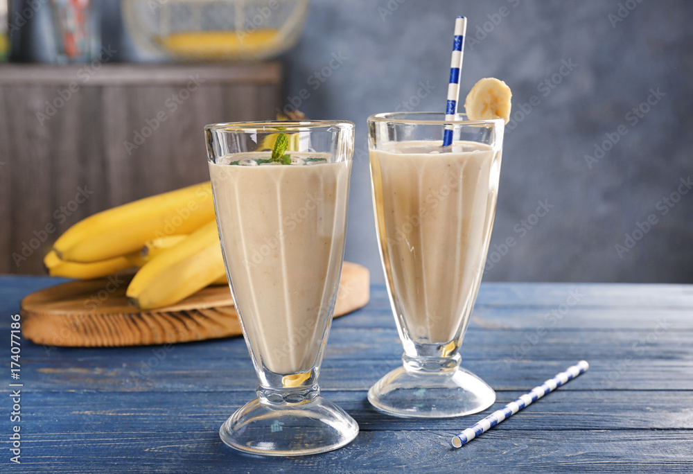 Glasses with delicious banana smoothie on wooden table