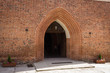 Miasto Reszel, wejście do zabytkowego kościoła z czerwonej cegły, mazury