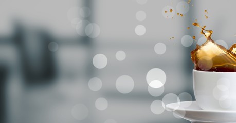 Poster - White cup with coffee splashing and bokeh against blurry grey