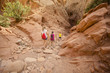 © Brocreative - Family hiking together in a sandstone slot canyon near Arches National Park