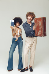 Wall Mural - Retro loving couple holding suitcase passport and tickets.