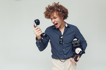 Wall Mural - Screaming angry retro man with telephone in hands.