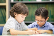 © Jestercine - Portrait of two boy writing on paper at classroom together, Children with education concept.