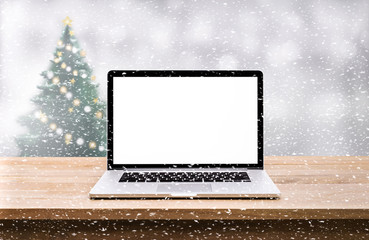 Canvas Print - Computer,laptop with blank screen on snowfall in white.christmas winter backgrounds