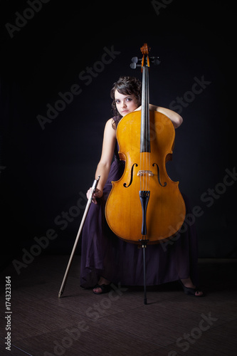Zdjęcie XXL dziewczyna z wiolonczelą na ciemnym tle
