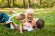 © justesfir - Family concept, mother and her daughter and son together playing and laughing on the grass