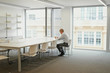 © Aila Images/Stocksy - Businessman working alone in boardroom after hours