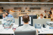 © Aila Images/Stocksy - Back of businessman using headset facing coworkers rear view