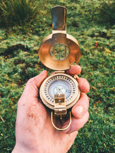 A Close-up Of A Hand Holding An Old Compass.