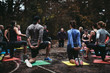 © Rob and Julia Campbell/Stocksy - Fit people stretching arms and back outside in group workout