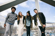 © BONNINSTUDIO/Stocksy - Portrait of group of young friends standing on a modern bridge.