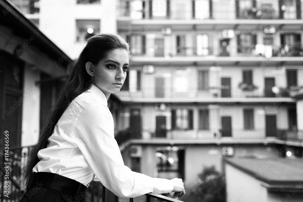 Attractive woman leaning against a railing with typical old building of ...