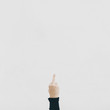 © Luca Pierro/Stocksy - Middle finger against a white wall