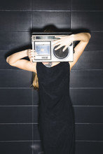 Back View Of Young Woman Holding Vintage Tape-recorder