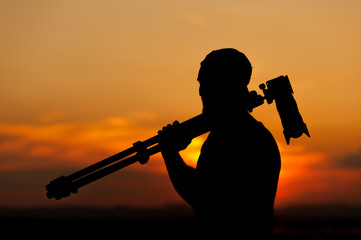 Wall Mural - Male photographer holding camera and tripod