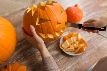 Wall Mural - close up of woman carving halloween pumpkin