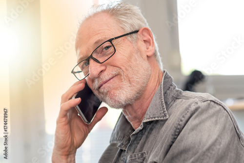 Plakat Portret uśmiechnięty dorośleć mężczyzna opowiada na telefonie, lekki skutek