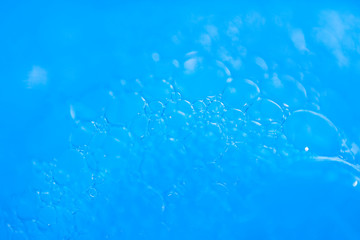 Macro view white soapy bubbles foam. suds and shower texture. Blue background. soft focus