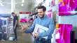 © Gorodenkoff - Young Man in Electronics Store Purchased Latest Model of the Tablet Computer and Dances Happily with the Box. Bright and Modern Store Has all the Latest Devices in Store.