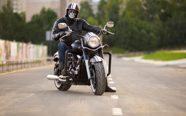 biker in mask sitting unknown on big chopper bike on road