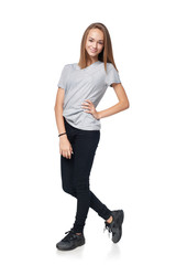 Wall Mural - Teen girl in full length posing with hand on hip smiling at camera, isolated on white background