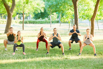 Group of young people doing exercise outdoors