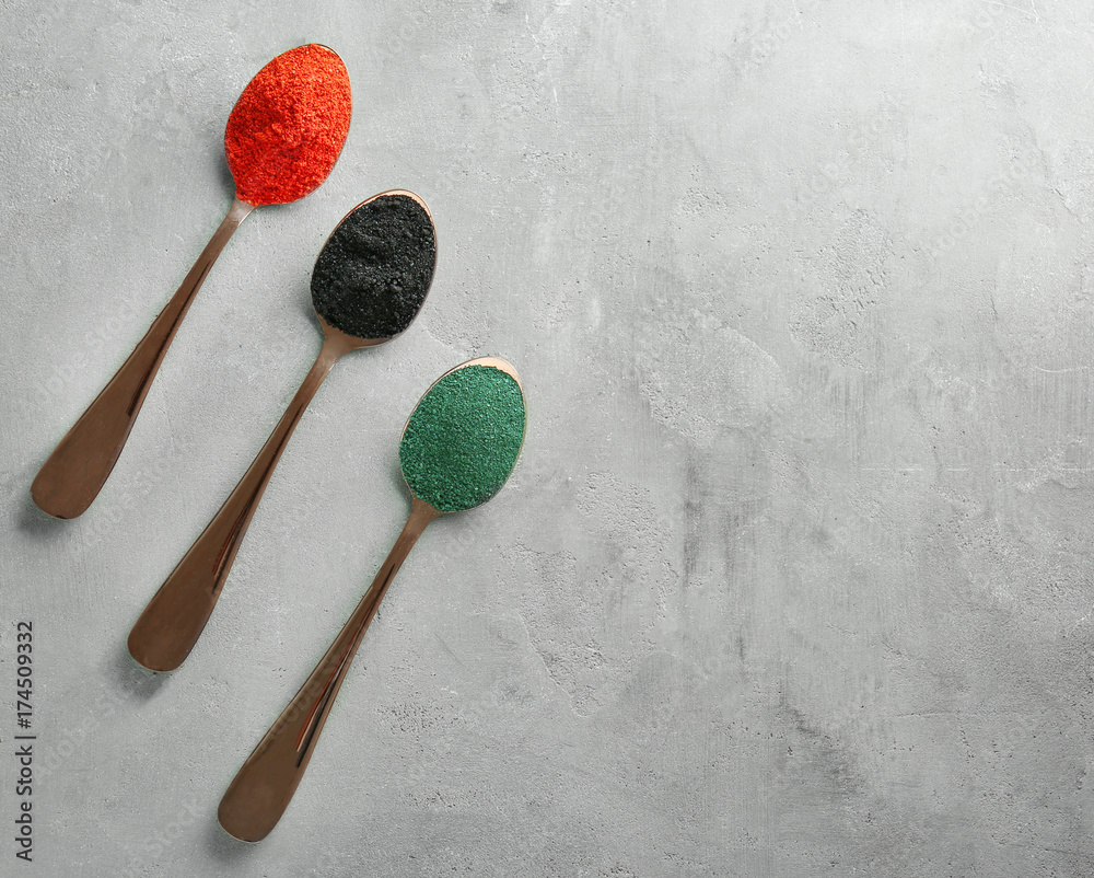 Different colorful superfood powders in spoons on table