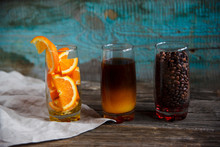 Layered Non-alcoholic Cocktail Recipe Idea. Orange Juice In The Bottom And Dark Coffee On The Top In The Glass. Bright And Cozy Still Life Of Coffee Beans, Orange Slices And Layered Cocktail.