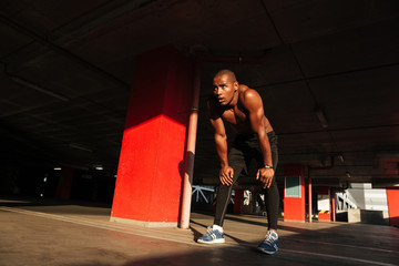 Wall Mural - Full length portrait of a tired exhausted african sportsman