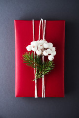 Wall Mural - christmas handmade gift boxes decorated with red paper, spruce and berries on dark grey background t