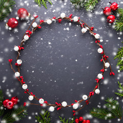 Wall Mural - frame with christmas wreath, berries, spruce tree and balls on dark background top view. merry chris