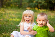 © justesfir - Funny little children - blonde little girl and boy sitting together, with copy space
