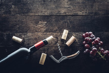 Bottle Of Wine, Corks And Grapes On Wooden Background
