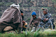 © Micky Wiswedel/Stocksy - A group of Basotho herdsmen sitting and talking in the mountains