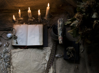 Magic fairytale table in the hut with window to the garden with open ancient book and burning candles